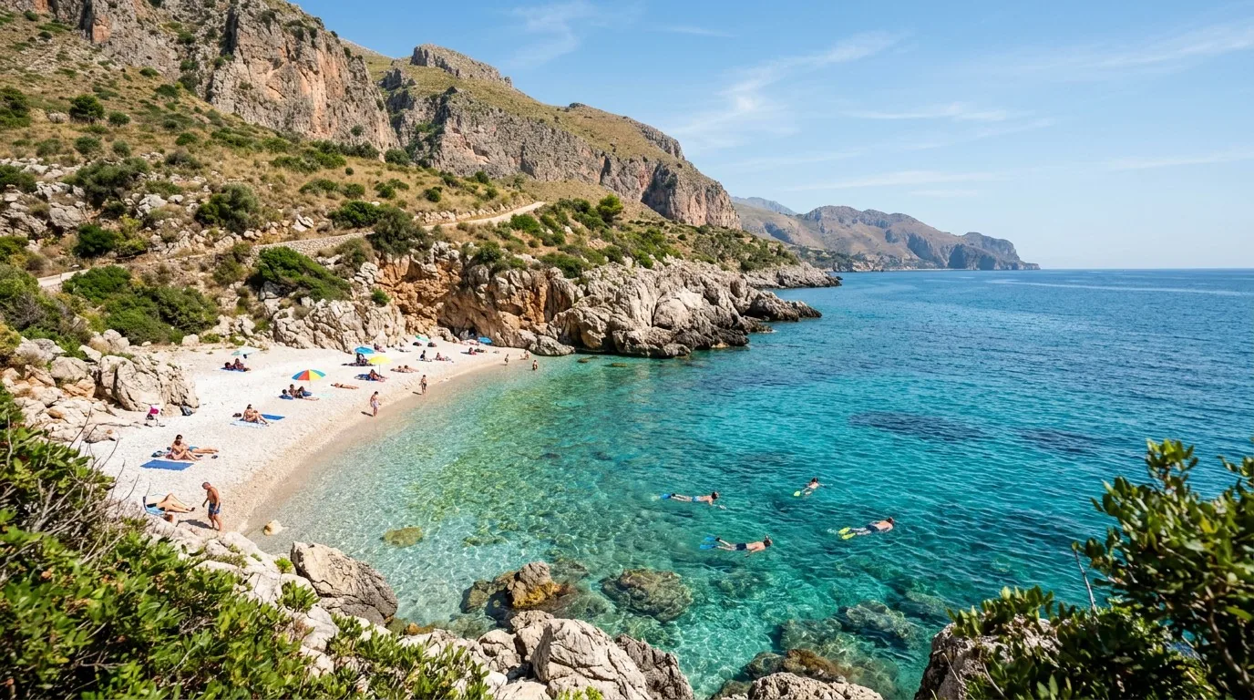 Cala Marinella in the heart of the Zingaro reserve — a crescent of pebbles under limestone cliffs.